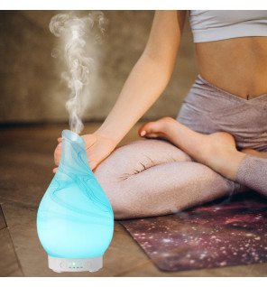  diffuseur ultrasonique yangtsé en verre peint à la main sur une table de chevet dans une chambre paisible