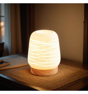  main déposant un fondant parfumé dans le brûleur pour une diffusion optimale