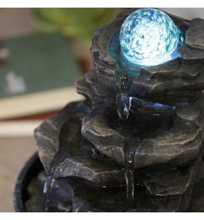  fontaine d'intérieur nature installée dans un coin détente avec plantes vertes