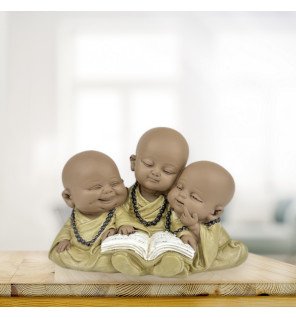  statue décorative bonzes lecture placée près de plantes vertes