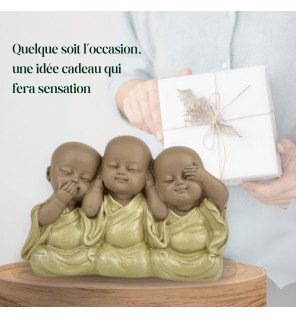  statue décorative bonzes embleme sur une table basse entourée de livres et de bougies