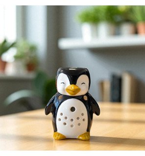  main versant de l’huile parfumée dans le brûle-parfum en forme de pingouin