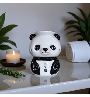  objet déco en céramique panda posé près d’un livre et d’une tasse de thé