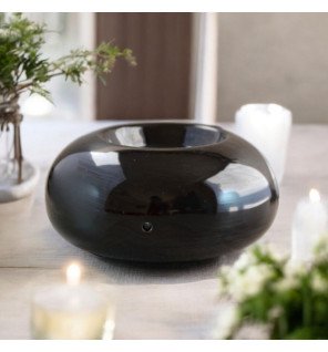  diffuseur en céramique noire sur une étagère minimaliste