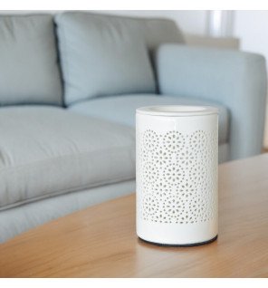  diffuseur de senteurs en céramique blanche placé sur un meuble en bois dans un décor épuré