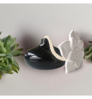  diffuseur décoratif placé près de plantes vertes pour une atmosphère naturelle et relaxante