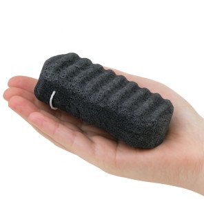 éponge konjac au charbon de bambou pour corps sun&sia posée sur une serviette blanche dans une salle de bain lumineuse