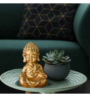  statuette décorative représentant un jeune bouddha doré en pleine méditation dans une ambiance apaisante