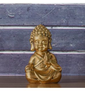  décoration intérieure zen avec baby bouddha doré en méditation sur une étagère minimaliste