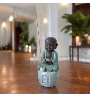  gros plan sur la main de la statue tenant délicatement le support à encens